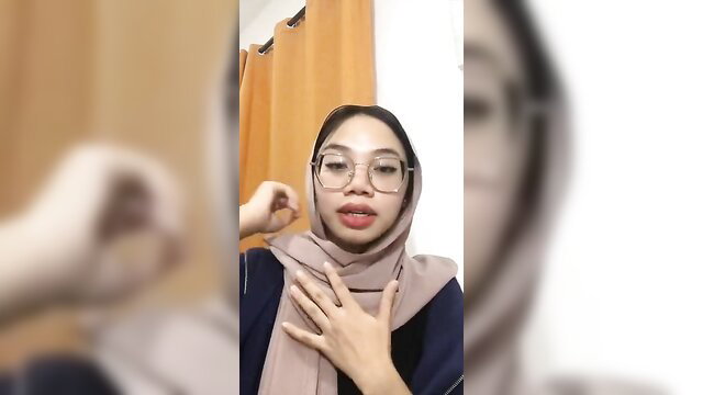 Malay hijab girl in glasses touching face seductively