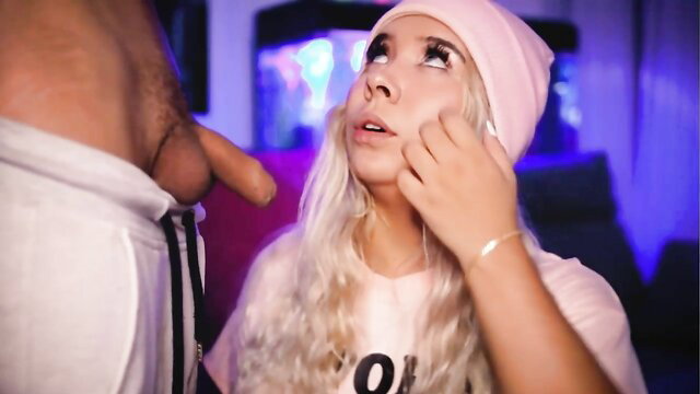 Horny blonde in pink beanie kneels for neighbor's cock on live cam