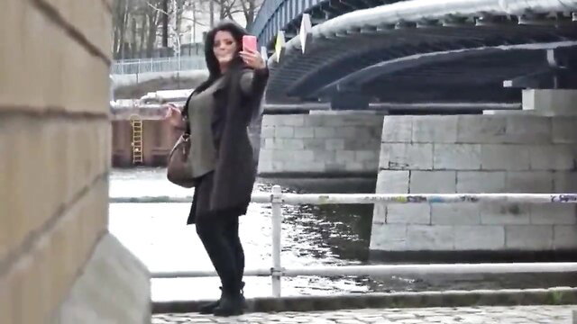Hot mature wife taking selfie by river bridge in coat and leggings