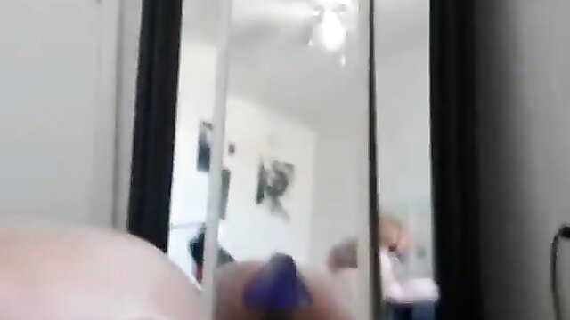 Curvy redhead teases with purple dildo on webcam mirror