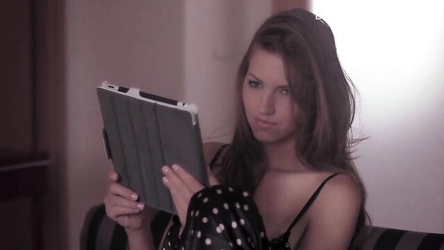 Beautiful brunette in polka dot lingerie holding tablet, sultry gaze