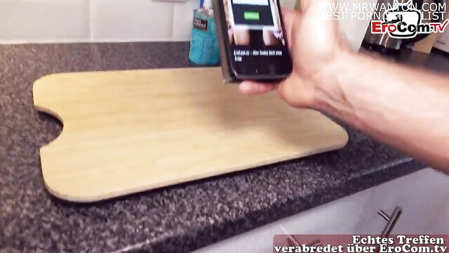 Tattooed big ass hooker charging phone on cutting board in kitchen