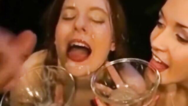 Two pretty brunettes drinking cum from glasses in hot bukkake scene
