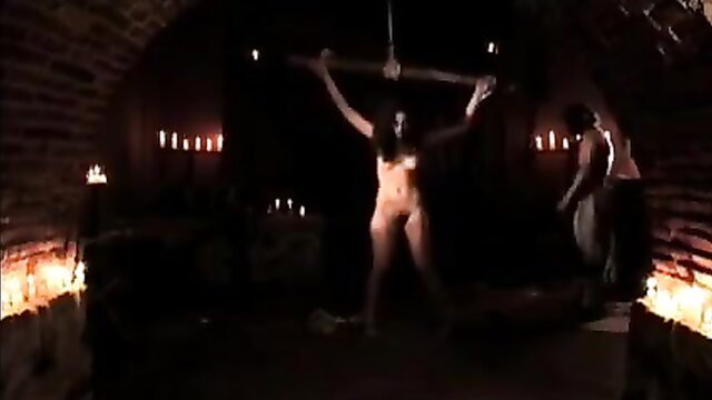 Nude brunette bound arms raised in dark ritual Maleficarum scene