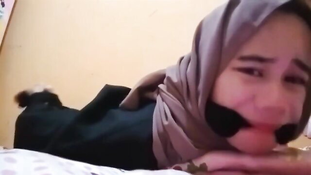 Hijab Indo girl gagged and bound on bed in amateur BDSM tease