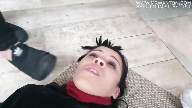 Hot brunette with mohawk lies on floor, foot near face in kinky tease