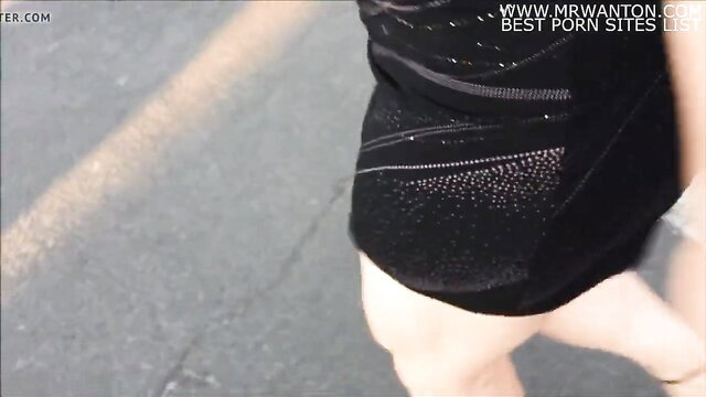 Hot blonde in tight sparkly black mini dress bends over at shoe store