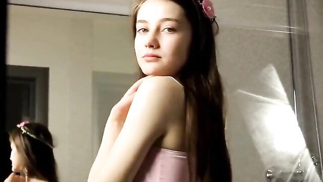 Teen brunette Alissa in pink tank top poses sexy in mirror