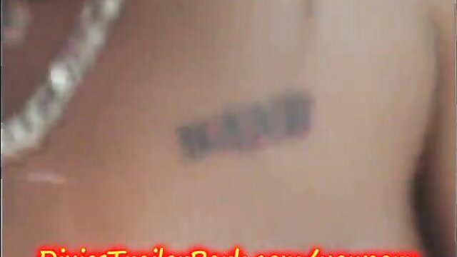 Closeup of woman's hip with KANYE tattoo and diamond necklace in adult video