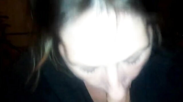Closeup of woman with pale skin and dark hair in dimly lit amateur blowjob thumbnail