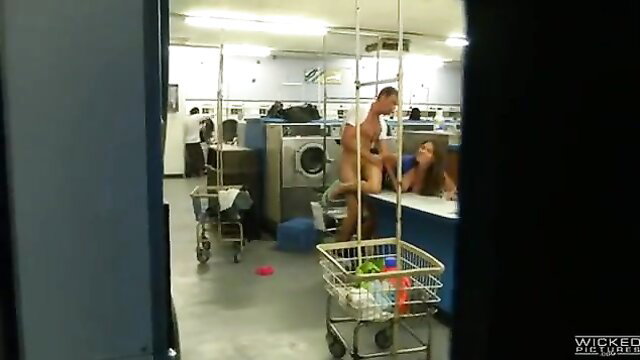 Nude guy fucking busty brunette over laundromat counter