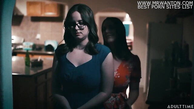 Angela White and Jay Taylor in kitchen, busty brunette stares intensely