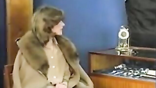 Mature brunette in fur coat and blouse on talk show, softcore tease