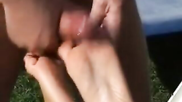 Hot footjob closeup with bare feet stroking swollen cock outdoors