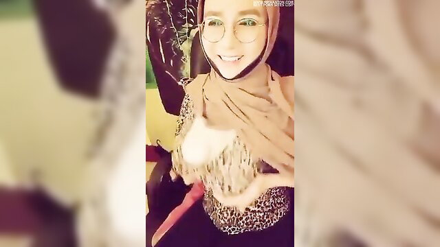 Hijab Asian woman smiling in cleavage-revealing leopard top