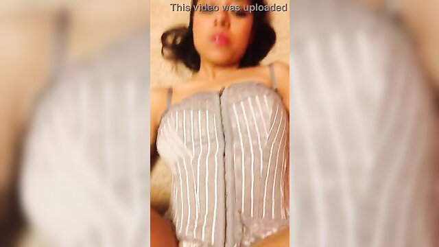 Latina woman in shiny gray corset lingerie, seductive gaze up close