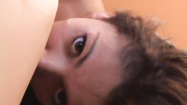 Closeup of stunning Asian beauty's wide eyes and full lips in erotic scene