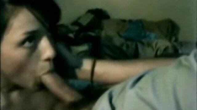 Brunette cutie deepthroating cock on bed in dim light