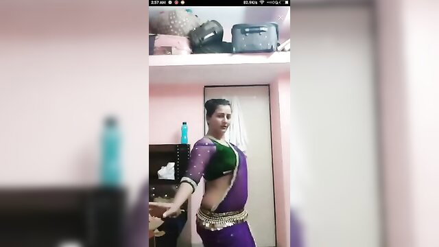Sexy Indian woman in sheer green blouse and purple saree exposing midriff