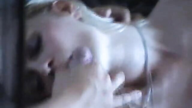 Blonde woman with pale skin kissed passionately on neck in bed