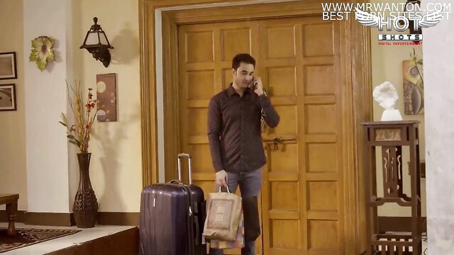 Handsome Indian man in black shirt with suitcase at door, seductive in-law tale
