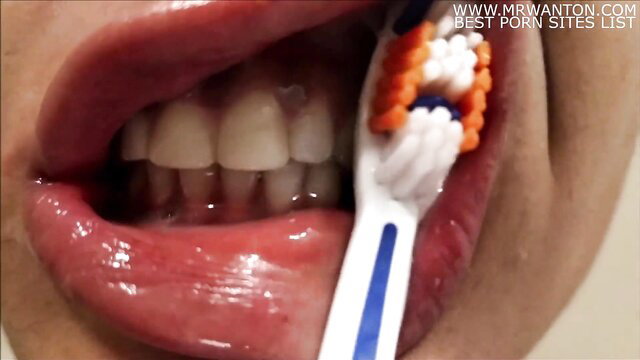 Closeup of woman's open mouth brushing teeth, spit dripping for vore fetish