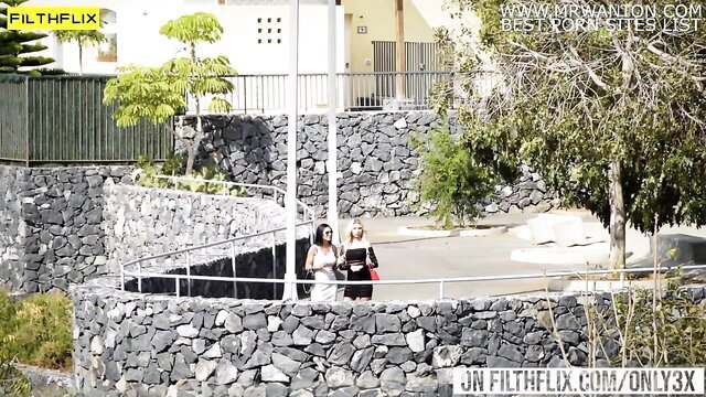 Two glam babes in dresses share cock outdoors at sunny resort