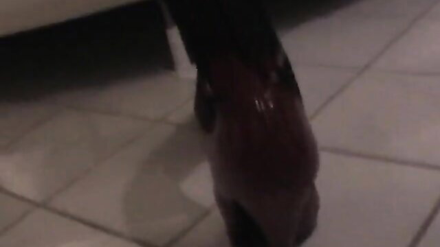 Mistress Angelique's glossy tight leather skirt and high heels closeup