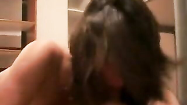 Closeup of woman with long dark hair sucking cock in amateur blowjob