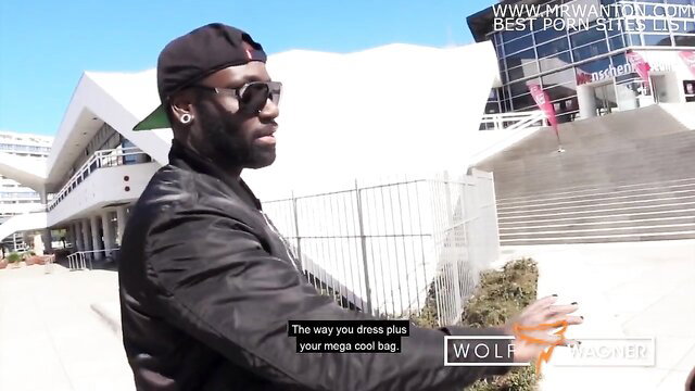 Black photographer Wolf Wagner in stylish black outfit at outdoor event