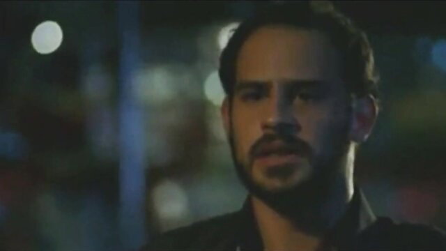 Handsome Latino man with beard in dark jacket, intense night gaze