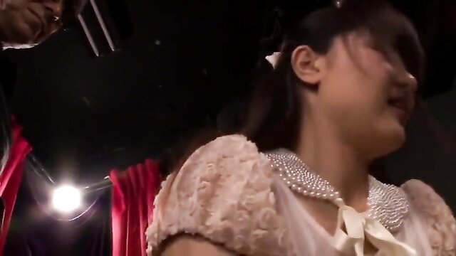 Asian teen in pink lace dress on stage, smiling at Anal Party 3