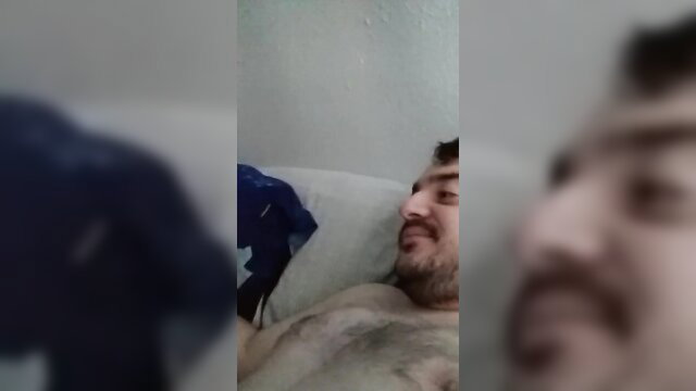 Hairy chest guy lying in bed getting head from unseen partner