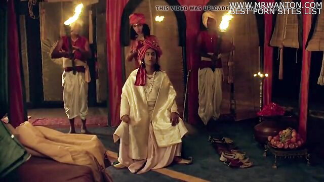 Indian king in white robe sits on bed with guards in ancient palace hot scene