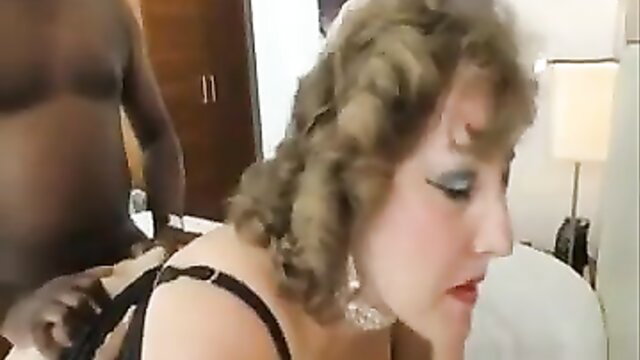 Busty British granny in lingerie with black man in hotel room