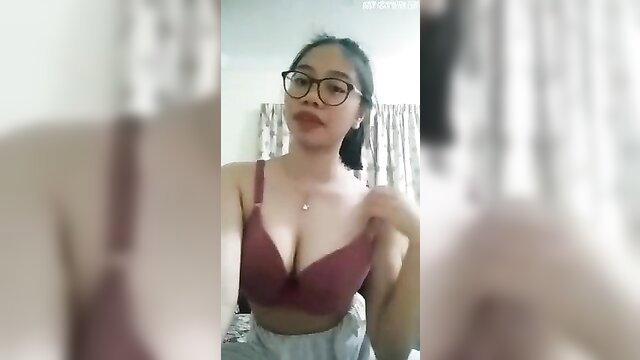 Malay girl in glasses and maroon bra, teasing cleavage closeup