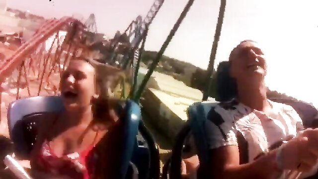 Blonde busty girl screaming on rollercoaster ride, cleavage spilling out