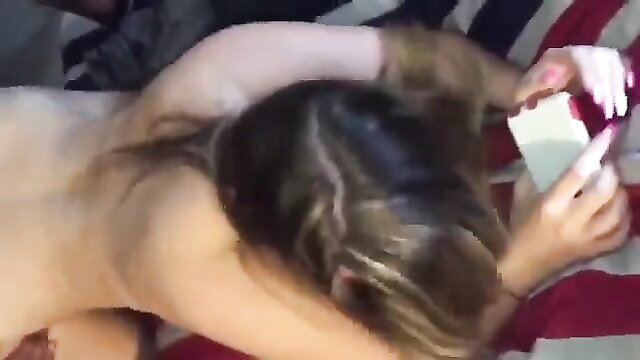 Nude snowbunny with blonde streaks on bed, holding phone nude