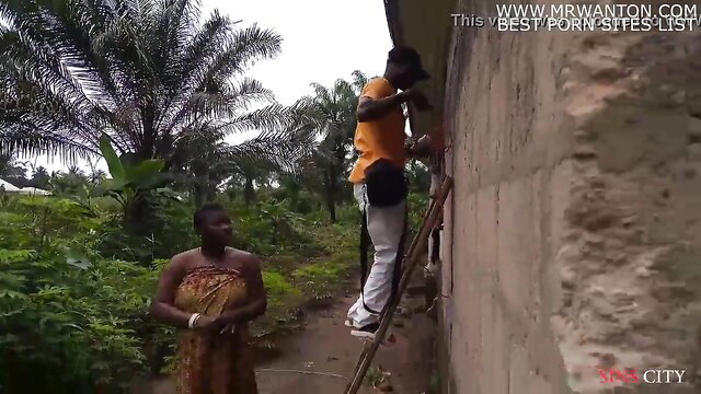 African woman watches electrician on ladder in outdoor hookup tease