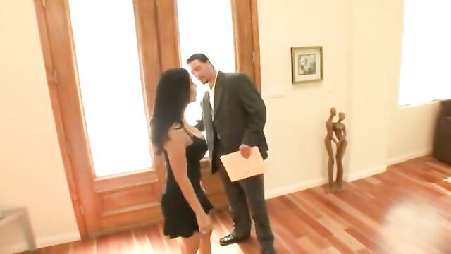 Hot brunette in black dress flirts with suited man in sunny room