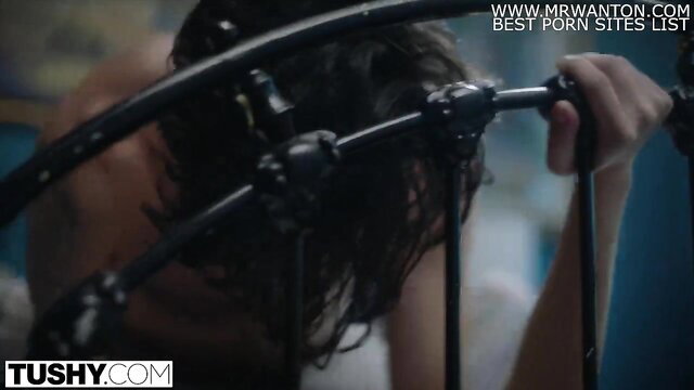 Abigail Mac gripping bedframe in steamy Tushy anal scene