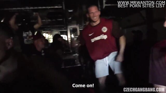Czech soccer player in red jersey urges on gangbang crowd at night