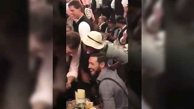 Oktoberfest Madness: Men in Lederhosen grope busty blonde in dirndl at crowded beer fest orgy