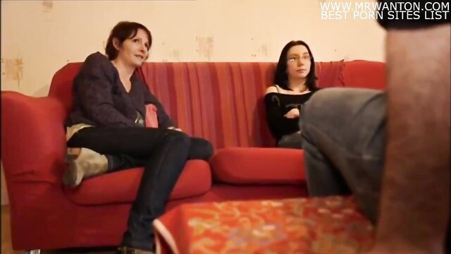 Two mature brunettes in tight jeans chatting on couch in amateur docu