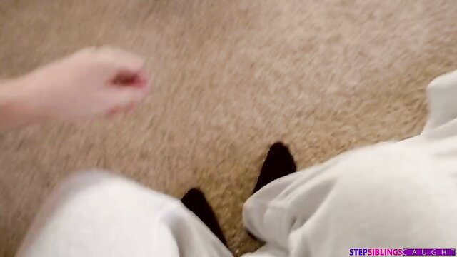 Megan Rain in white sweats and black socks with stepbrother on floor