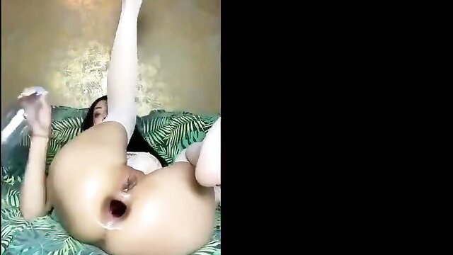 Asian woman gaping asshole after massive anal dildo insertion on bed