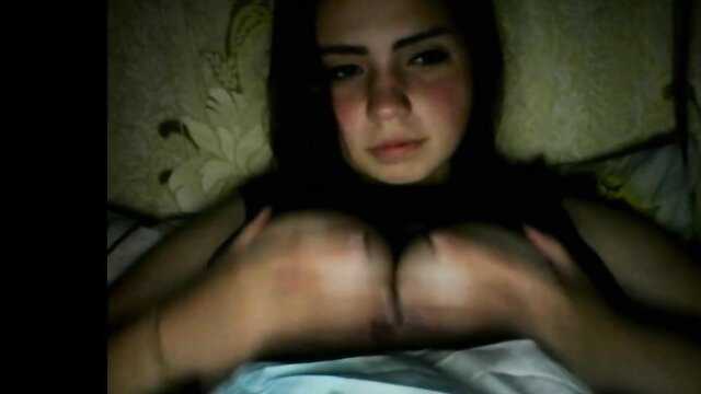 Beautiful brunette with huge natural tits squeezing them in bed