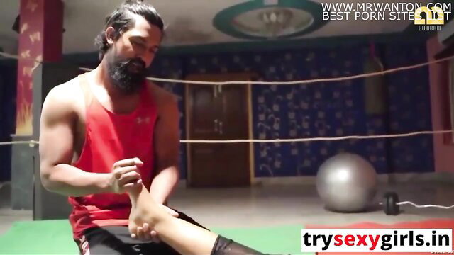 Muscular bearded Indian gym trainer massages hot model's foot