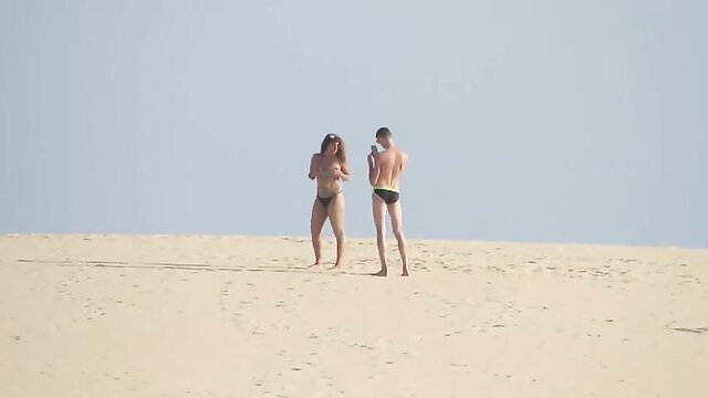 Nude brunette flashing knob to naked guy on sunny dunes beach