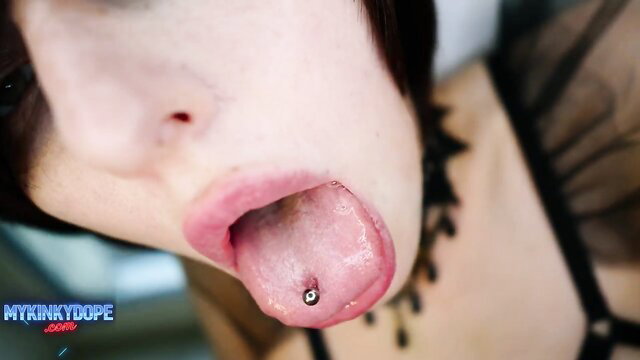 Closeup goth girl with tongue piercing sticks out tongue for voyeur BJ tease
